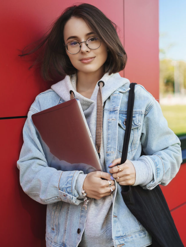 cropped education learning youth concept outdoor portrait dreamy thoughtful young woman glasses holding laptop as finish classes head co working space work freelance smiling camera